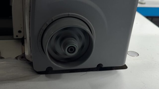 Rotating mechanism on sewing machine close up, textile equipment in operation and garment production concept