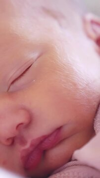 A baby girl is peacefully sleeping with her eyes closed. The baby girl has soft skin and delicate features, highlighting the calmness of her rest.