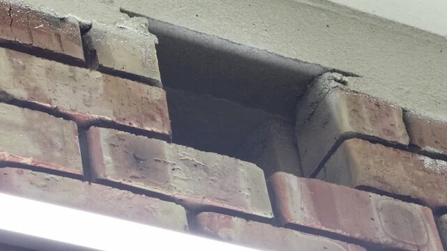 brick wall with exterior ventilation shaft near roof edge in close up, building airflow and exhaust system concept
