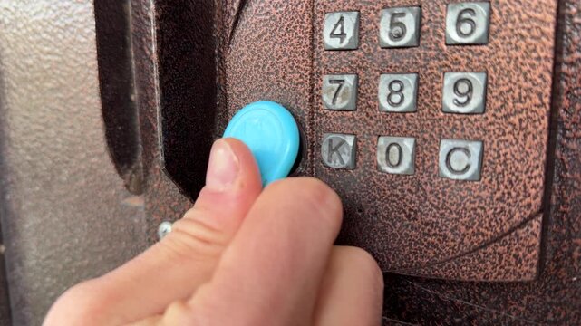 Person pressing intercom keypad button close up outdoors, entering code, access control system, security technology concept