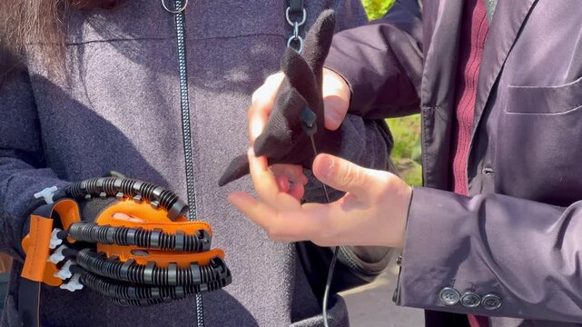 Person testing a haptic glove with a robotic exoskeleton
