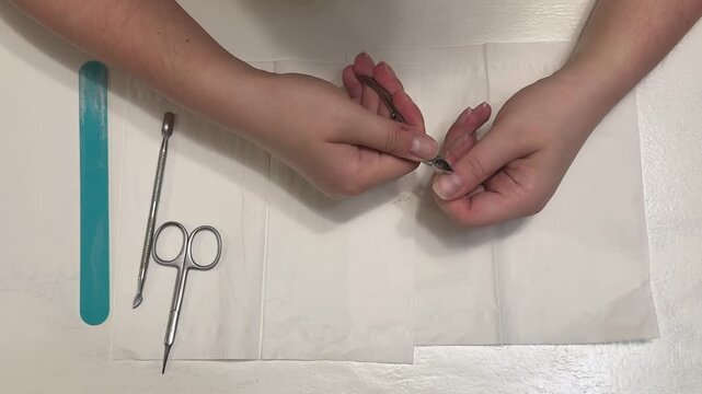 Close-up of cutting the cuticles with nail clippers during a home manicure, a professional nail care routine