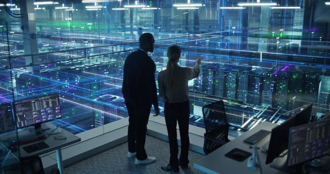 Male Specialist and Female Analyst Activate Information Flow in a Data Center, Using Computer Systems and Tablet to Monitor AI Computing Processes, Software and Data Analysis.