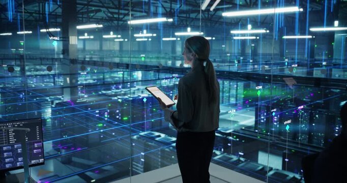 Portrait of Female Technology Specialist Activates Information Flows From a Tablet in Data Center. Elevated view of  Server Racks, AI Network Visualization, Cloud Operations, Digital Infrastructure
