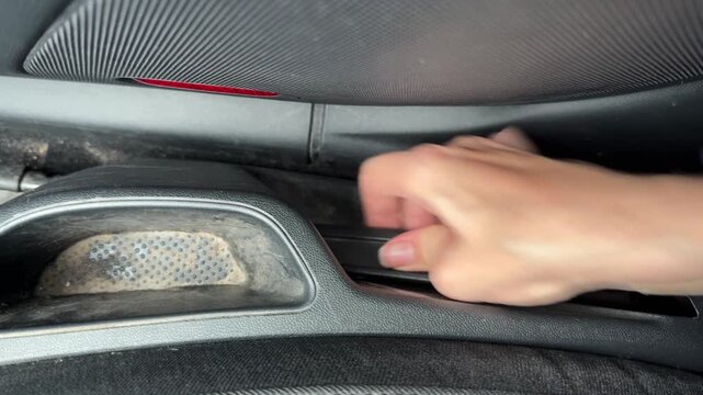 Hand adjusting car seat height lever inside modern vehicle cabin, comfort and ergonomic driving setup, automobile interior detail