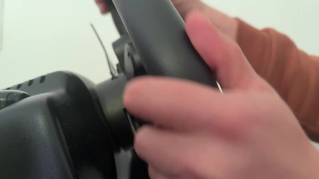 Hands turning racing simulator steering wheel controller, gaming driving setup and computer entertainment concept