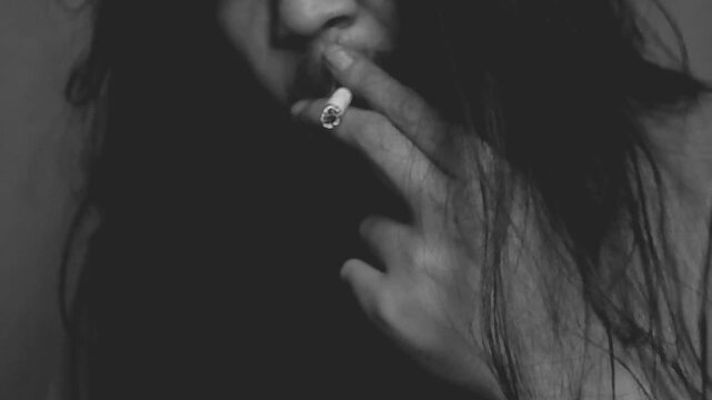Stressed person smoking cigarette in low light room emotional concept