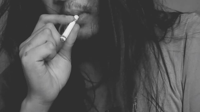 Stressed person smoking cigarette in low light room emotional concept