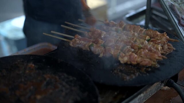 Close up shot of sausage meat satay on grill