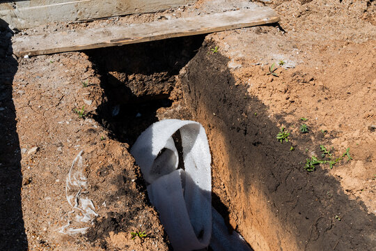 Trench Setup Details. Drainage Pipe And Soil Preparation. Construction Of Waterproof Trench With Drainage System. Installation Of Protective Trench With Filtration And Water Flow Focus