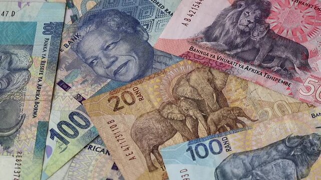 Close-up of scattered South African Rand banknotes (ZAR 20, 50, 100 denominations). Concept for South Africa's financial growth, banking sector, investment, business wealth, and economic prosperity.