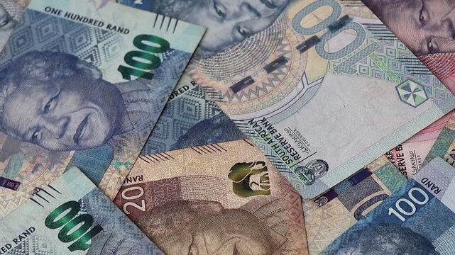 Close-up of scattered South African Rand banknotes in 20, 50, and 100 ZAR denominations. Conceptual shot of South Africa's financial system, banking sector, national currency, and wealth investment