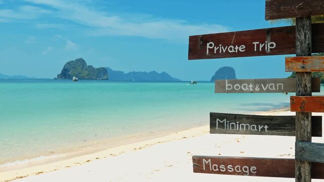Wooden signpost displaying tourist services, tropical beach with turquoise water and limestone islands, travel agency marketing background, summer vacation promotion