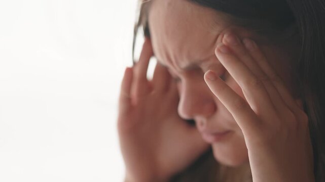 girl has a headache. girl rubs whiskey headache close-up. migraine health medicine concept. sick unhealthy woman suffering from dizziness overloaded at work. migraine concept lifestyle