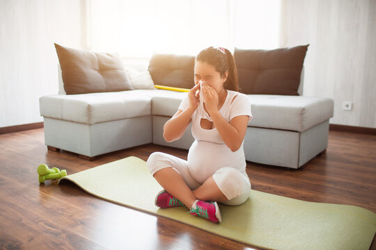 A pregnant woman works out on a yoga mat at home. Pregnancy and sports. Oga and Pilates for pregnant women. Third trimester of pregnancy