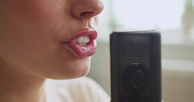 Woman's lips speaking into a professional studio microphone