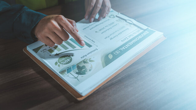 ESG environmental sustainability net zero strategy concept engineer hand pointing at carbon footprint emission reduction report chart green energy climate change corporate responsibility