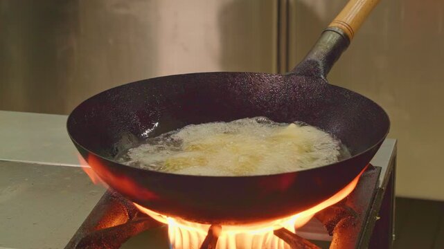 Traditional cuisine of ancient nomads. Festive dish for Nauryz.
Person stirring baursaks in cast iron cauldron with slotted spoon. The national bread of the Kyrgyz, Tajiks, Uzbeks