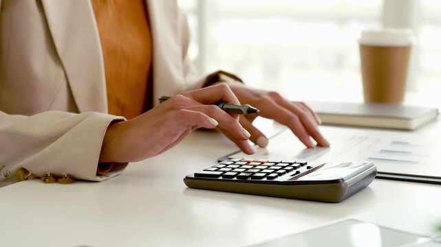 Close up Business woman hand doing finances and calculate on desk about cost . Woman working on desk with using calculator, finance accounting. Business finance accounting banking concept.