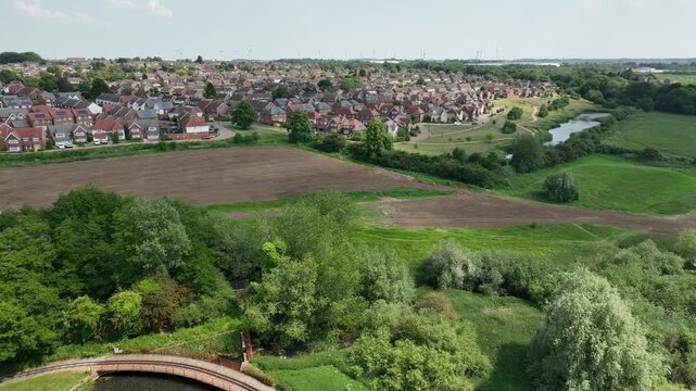 Aerial View of Suburban Housing Estate with Circular Pond Water Feature near Nature Reserve in Barton Seagrave Kettering England UK