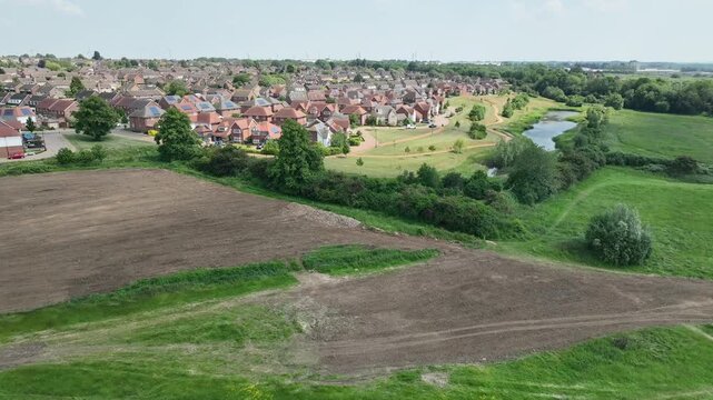 Aerial Drone View of Plowed Farmland Bordering Suburban Housing and South Meadow Nature Reserve in Barton Seagrave England