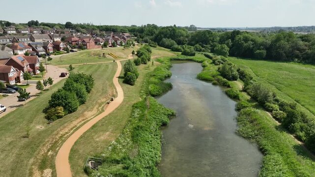 Aerial Close Up of Winding River Through South Meadow Nature Reserve with Suburban Houses in Barton Seagrave Kettering England UK
