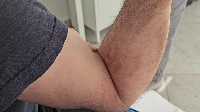 Medical worker applying adhesive bandage on male arm vein after blood test procedure in modern clinic laboratory during professional healthcare examination