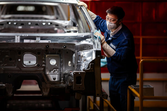 Asian workers are building car production lines.
