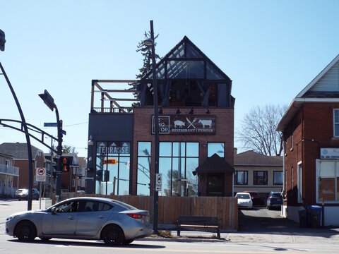 Gatineau, Quebec, Canada &ndash; April 17, 2026: "Le BBQ Shop restaurant and fumoir" features a brick facade, glass terrace, and wooden fence at 315 Boulevard Saint-Joseph.