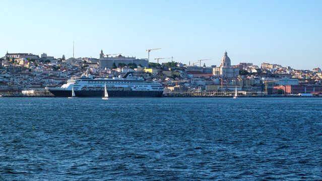 View of the historic Lisbon skyline featuring the National Pantheon and a large cruise ship docked at the port across the Tagus River in Lisbon, Lisbon, Portugal.