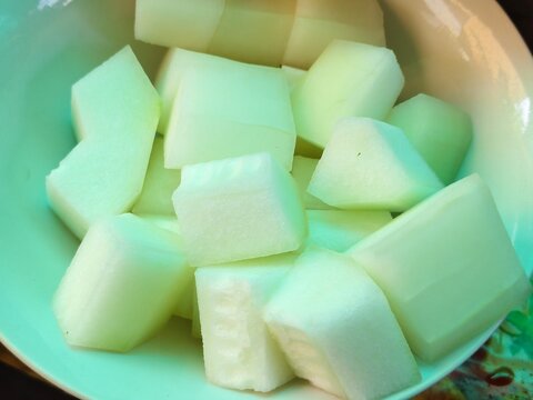 Close-up of fresh peeled and cubed winter melon pieces in a bowl, ready for cooking soup.
