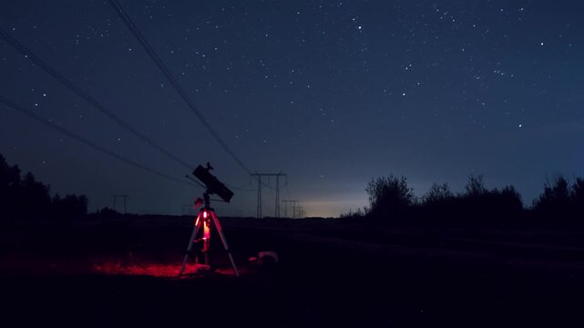 Tripod and telescope under starfield, red status light illuminating foreground, camera set for Perseids timelapse, transmission towers on horizon, intimate fieldwork atmosphere and precise gear