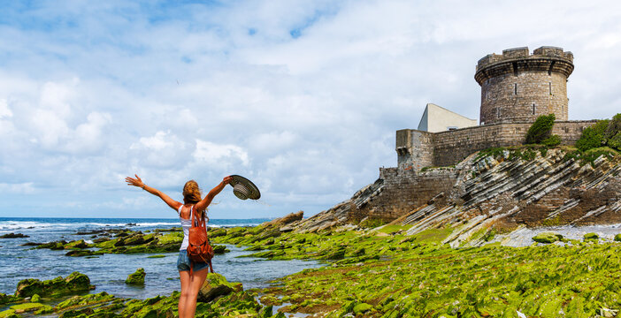 Traveler happy woman traveler enjoying the view of fort de socoa in saint-jean-de-luz. Travel destination, tour tourism in France