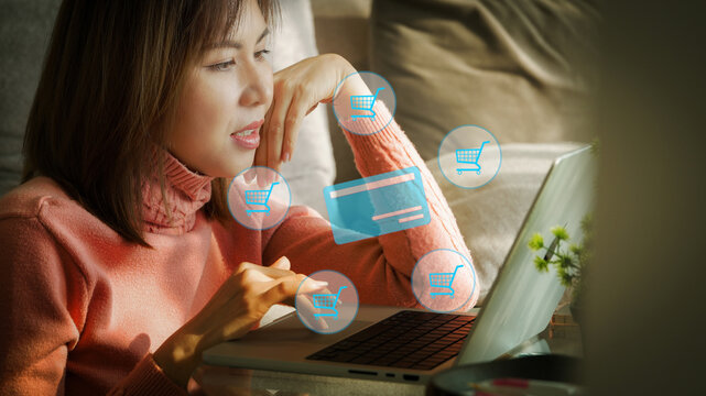 Asian woman shopping online with credit card on laptop at home enjoying convenient digital lifestyle and secure online payment