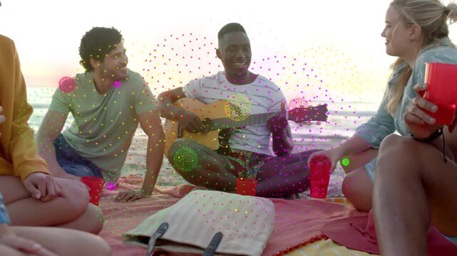 Guitarist picking guitar, starting music on beach picnic, friends holding red cups, overlay growing