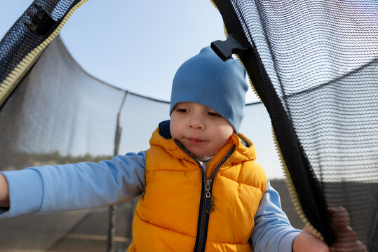 Toddler boy playing happily on trampoline outdoors