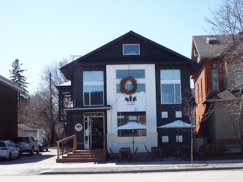 Gatineau, Quebec, Canada &ndash; April 17, 2026: "Aux Trois Licornes," a caf&eacute; with a black and white facade, features an outdoor patio and wreath in Gatineau at 335 Boulevard Saint-Joseph.
