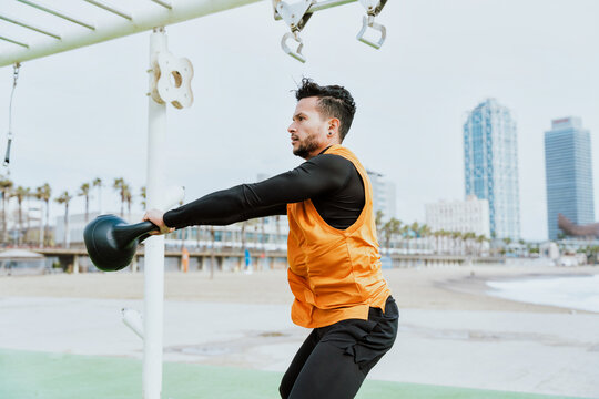 Young athlete training in the morning on the beach at the gym