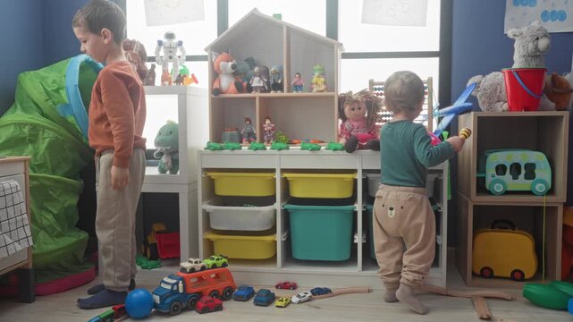 Boy playing with wooden train and toy cars, reaches for shelf of stuffed animals in building; curiosity focus.