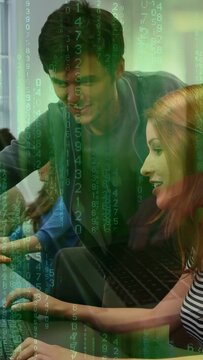 Vertical video: Male coming guiding woman typing on laptop for training, green code falling across