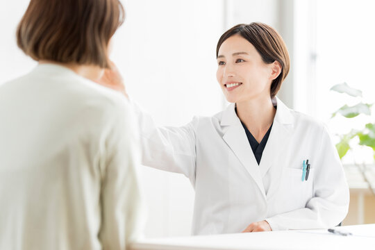 患者を診察する白衣姿の日本人女性医師