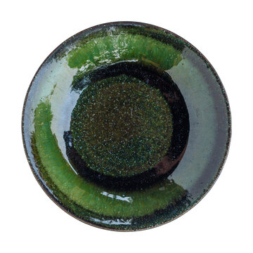 Top view of Japanese Oribe style ceramic plate with deep green glaze isolated on white background.