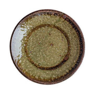 Top view of rustic antique style ceramic plate with reactive bronze glaze isolated on white background.