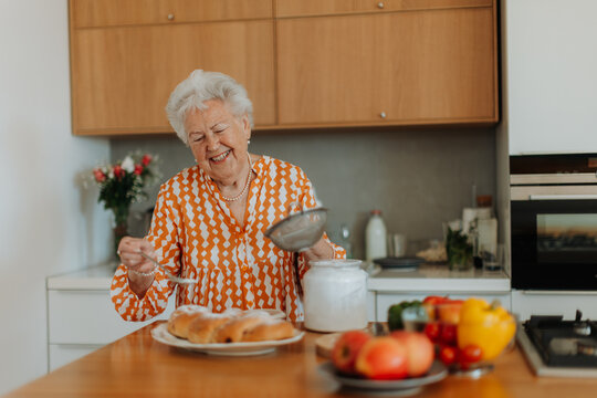 Happy senior woman with homemade easter braided bread with raisins. Close-up.