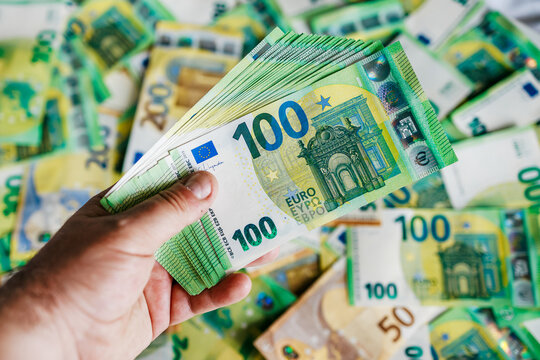 Hand gripping several 100 euro notes, detailed close-up composition. Concept finance and money management.
