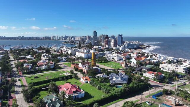 Punta Del Este Lighthouse In Punta Del Este Maldonado Uruguay. Turquoise Ocean Waves Gently Crashing On Tropical Beach. Metropole Skyline Panoramic City View Beautiful.
