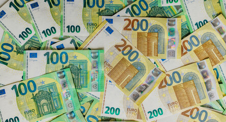 Obraz premium Detailed euro money layout with mixed denominations and 100 and 200 euro bills on surface. Concept economy. 