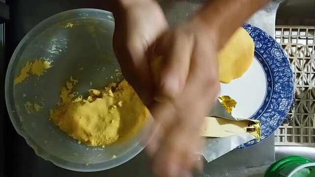 An unrecognizable person is preparing delicious corn arepas for breakfast inside a typical Colombian home in Bosa, Bogot&aacute;, Colombia. Concept of domestic life and artisanal food