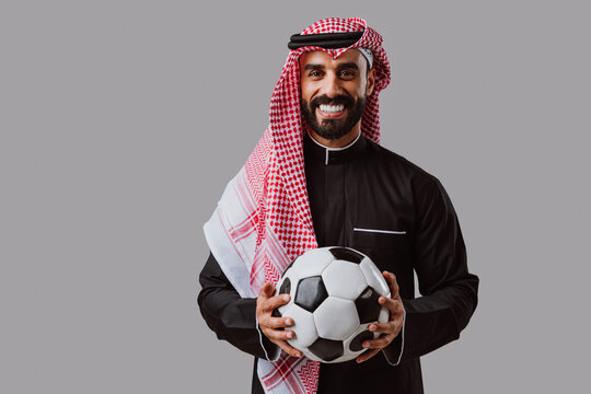 Arab man smiling holding a soccer ball