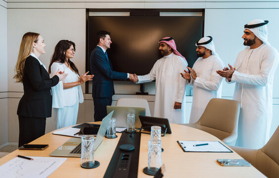 Diverse business professionals shaking hands forming partnership